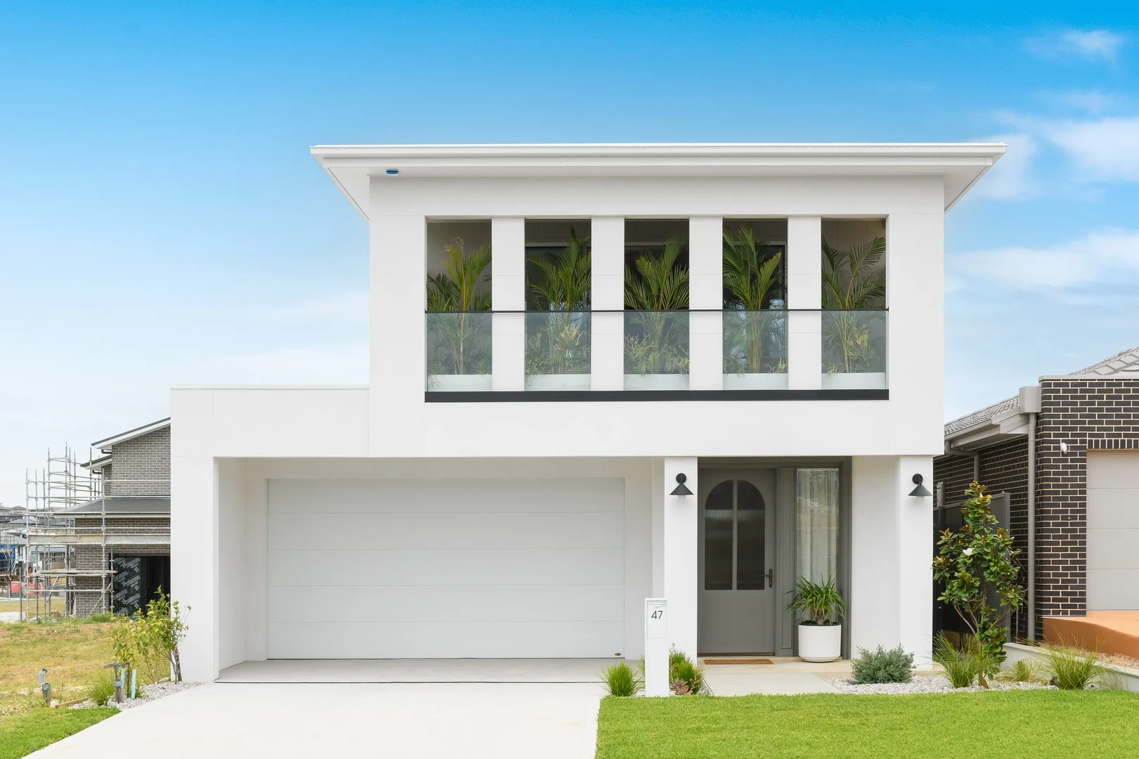 The completed Channel Nine home with a crisp white facade and landscaped front garden